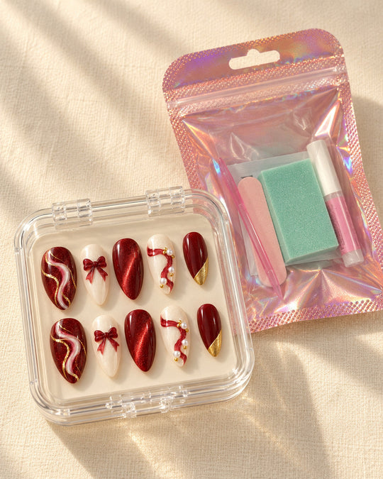 Midnight Ribbon hand-painted press-on nails — in clear case beside application kit. Design preview.