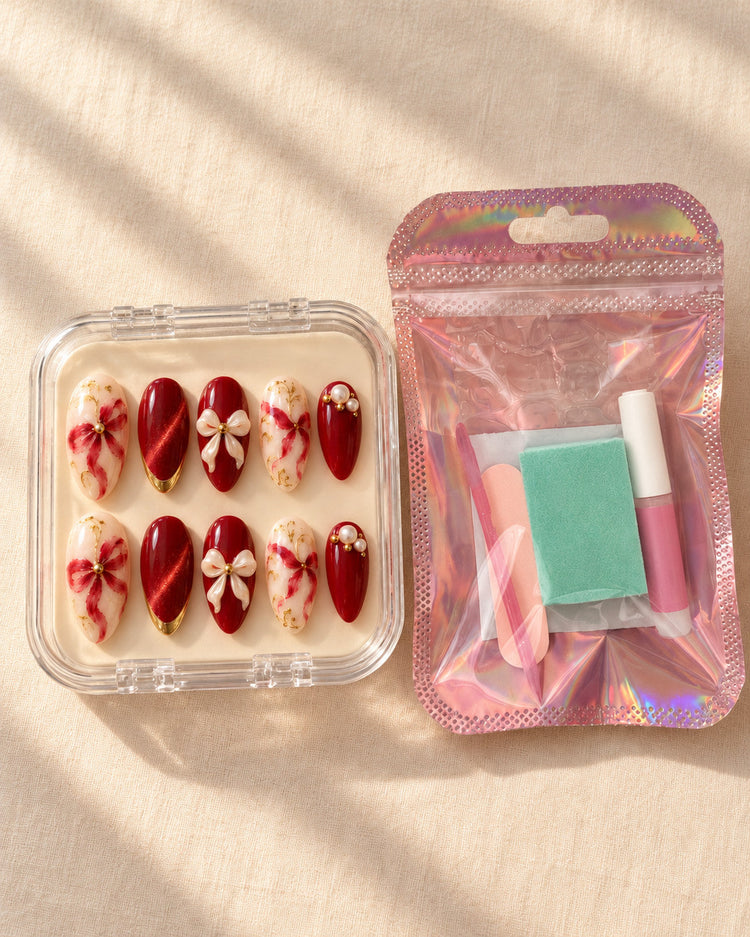 Gilded Knot hand-painted press-on nails — in clear case beside application kit. Design preview.