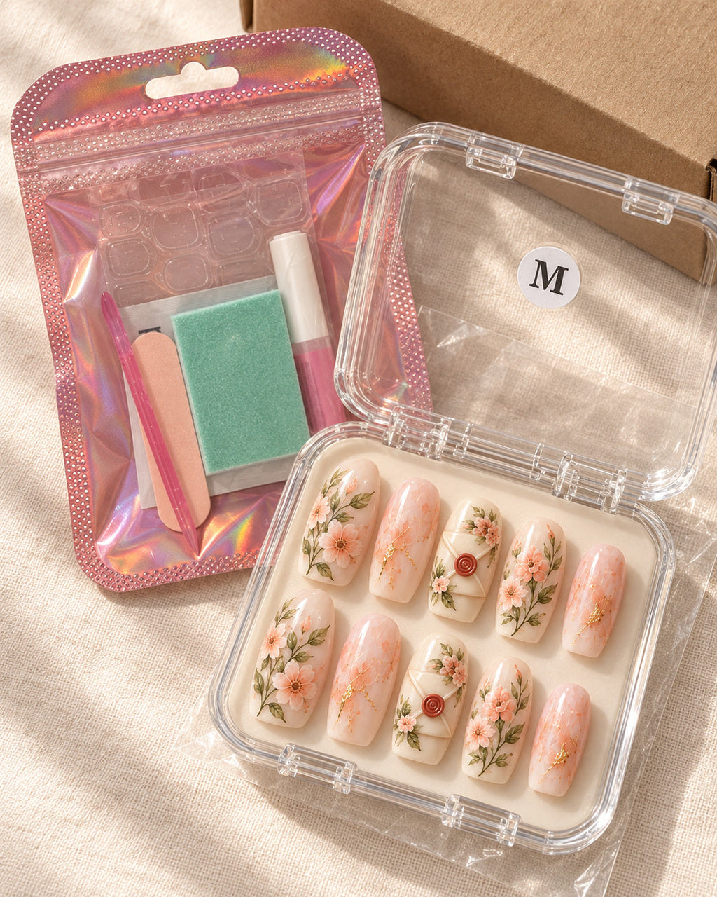 Sealed Romance nails in a clear case beside the pink application kit. Design preview.