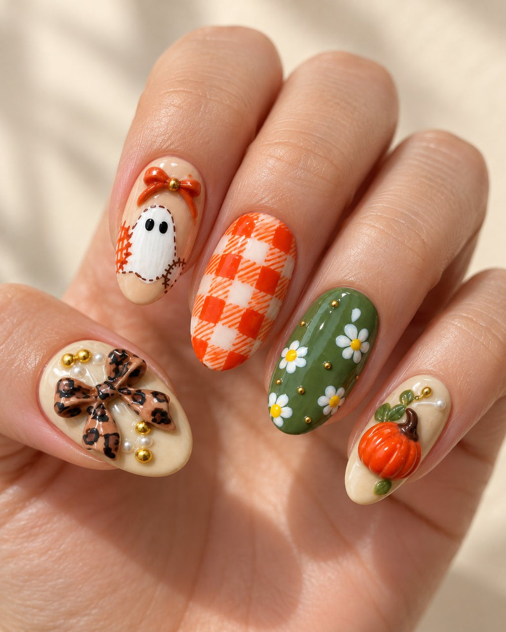 Autumn Patchwork hand-painted press-on nails shown on a hand